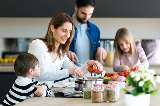 Beautiful cute family having fun while cooking together in the kitchen at home. - Photo, image