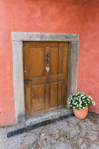 χαμηλή και μικρή πόρτα κελάρι με ένα στολίδι σε σχήμα καρδιάς και - Φωτογραφία, εικόνα