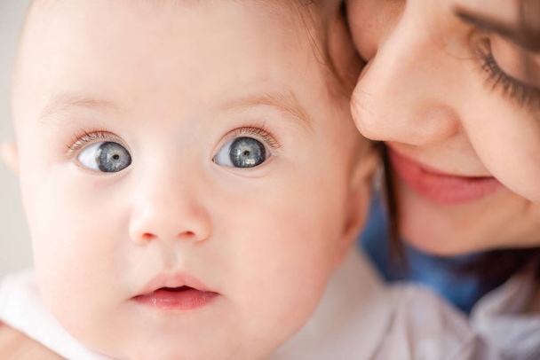 Madre susurra al oído del bebé de cerca
 - Foto, imagen