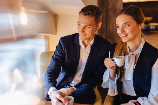 Ένα κομψό ζευγάρι πίνει καφέ το πρωί στο café, νέους επιχειρηματίες και ελεύθερους επαγγελματίες - Φωτογραφία, εικόνα