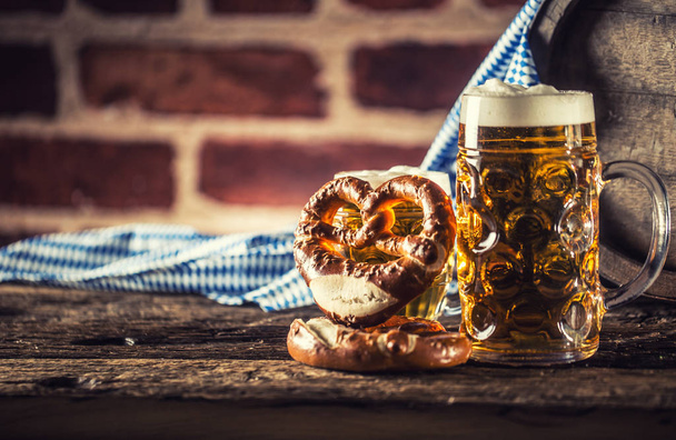 Oktoberfest large and small beer with pretzel wooden barrel and blue tablecloth - Fotó, kép