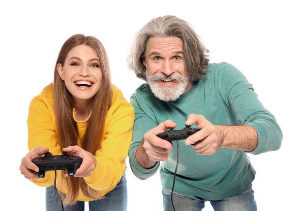 Mature man and young woman playing video games with controllers isolated on white - Photo, Image