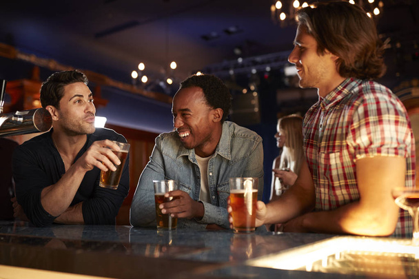 Group Of Male Friends Drinking Beer In Bar Together - Fotoğraf, Görsel