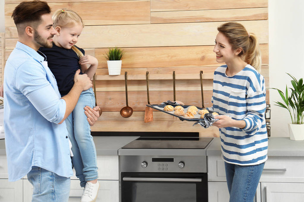 Young woman treating her family with homemade oven baked cookies in kitchen - Zdjęcie, obraz