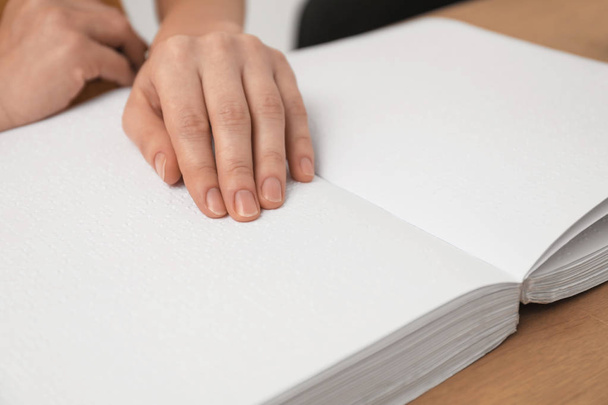Blind woman reading book written in Braille, closeup - Photo, image