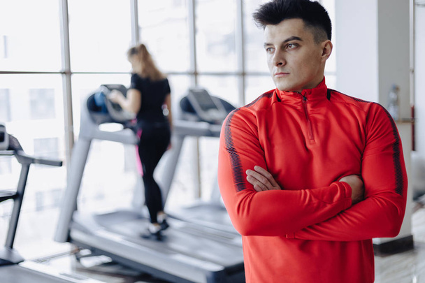 boyfriend coach in the gym on the background of people on treadmills - 写真・画像