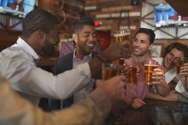 Group Of Male Friends On Night Out For Bachelor Party In Bar Making Toast Together - Photo, Image