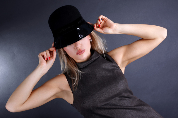 Fashion young woman in hat hiding eyes - Foto, afbeelding