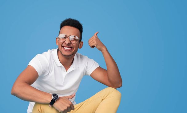Cheerful black male smiling and gesturing thumbs up - Foto, afbeelding