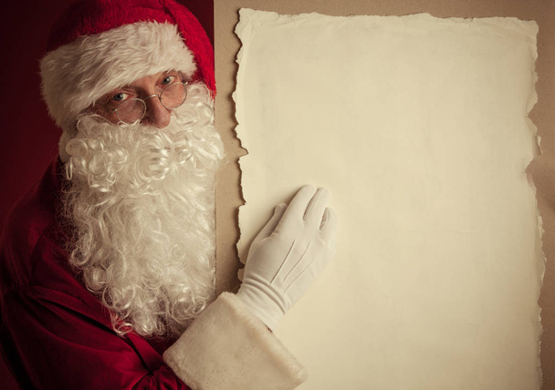 Santa Claus holding vintage paper billboard with copy space for text - Zdjęcie, obraz
