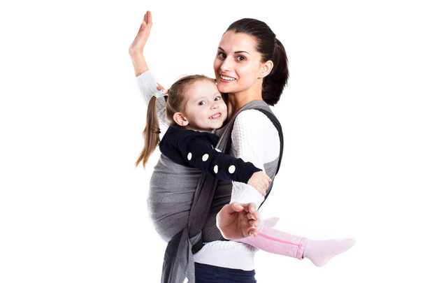 Mother and girl child in baby carrier having fun together - Fotografie, Obrázek