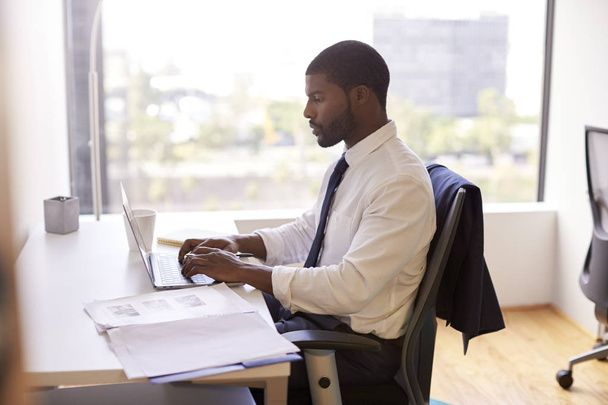 Businessman Sitting At Desk Working On Laptop In Modern Office - Valokuva, kuva