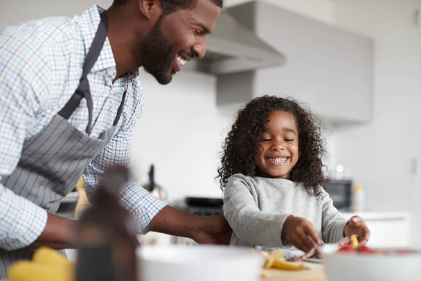 Padre e figlia in cucina a casa a fare frittelle insieme
 - Foto, immagini