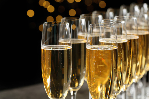 Many glasses of champagne on blurred background, closeup - 写真・画像