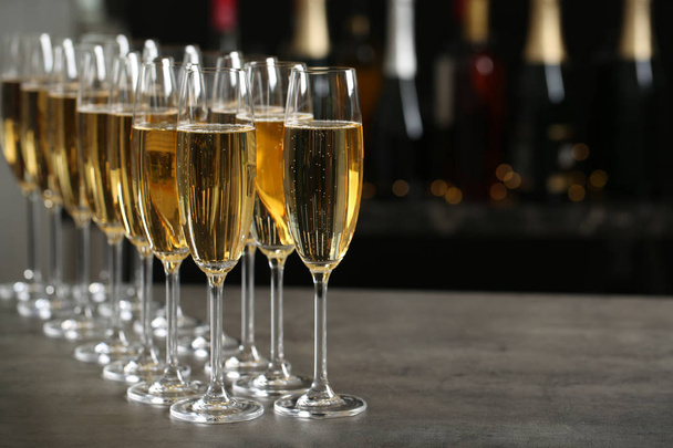 Glasses of champagne on table against blurred background. Space for text - Foto, Imagem