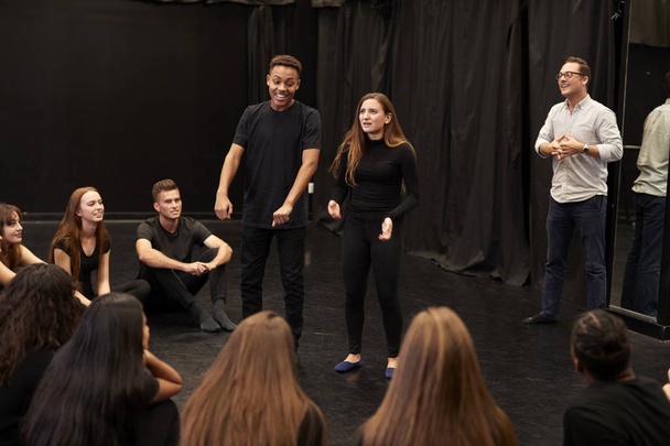 Teacher With Male And Female Drama Students At Performing Arts School In Studio Improvisation Class - Foto, imagen