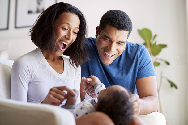 Happy mixed race young adult parents playing with three month old baby son - Photo, Image