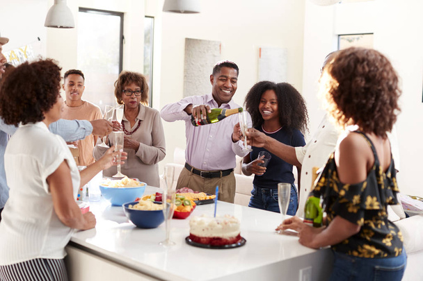 Three generation black family raising glasses to make a toast during a celebration at home - Foto, Bild