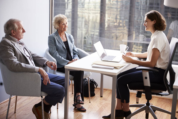 Smiling Senior Couple Meeting With Female Financial Advisor In Office - Foto, imagen