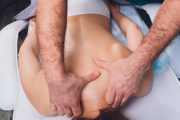 Jonge mooie vrouw met massage in Spa Salon Physiotherapis. - Foto, afbeelding