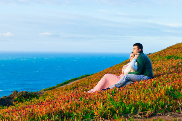 The guy and the girl are sitting on the grass and embracing. adm - Photo, Image