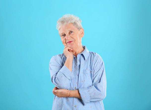 Portrait of grandmother in stylish clothes on color background - Foto, Imagem