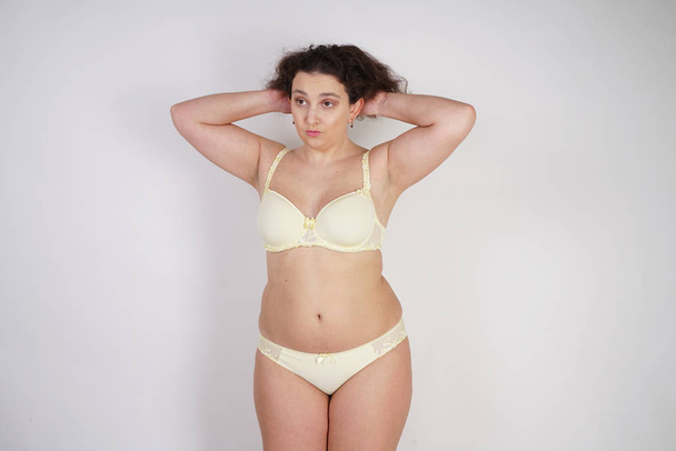naisellinen nainen plus koko kehon keltainen alusvaatteet poseeraa valkoisella taustalla Studio
 - Valokuva, kuva