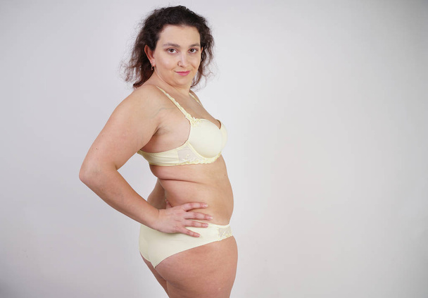 Stüdyo beyaz arka planda sarı iç çamaşırı poz artı boyutu vücut ile kadınsı kadın - Fotoğraf, Görsel