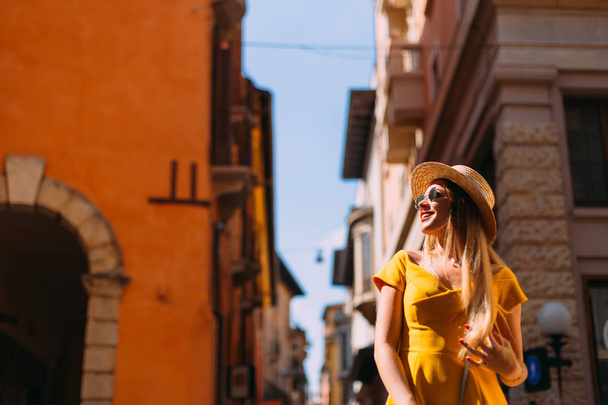 junge schöne stilvolle Frau zu Fuß in gelbem Kleid, hält h - Foto, Bild