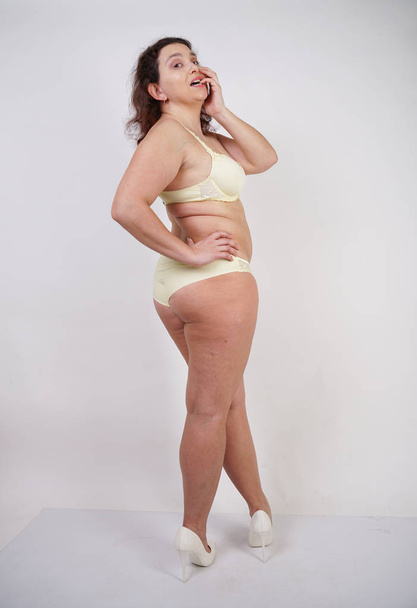 femme féminine avec corps taille plus en lingerie jaune posant sur fond blanc dans Studio
 - Photo, image