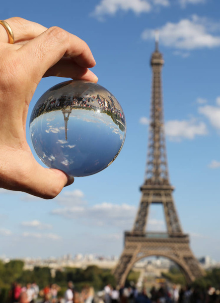 Big Crystal Sphere on the hand with wedding ring and the Eiffel  - Photo, Image