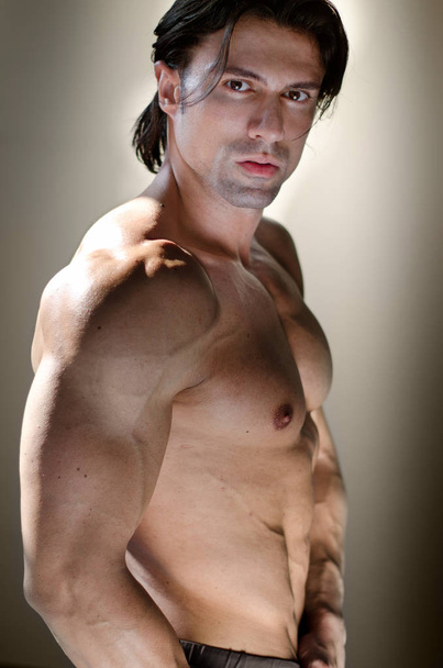 Shirtless muscular man on neutral background looking at camera - Foto, afbeelding