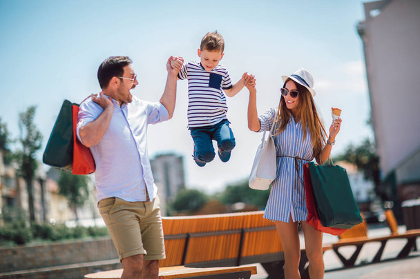 Счастливая семья веселится на свежем воздухе после шопинга
 - Фото, изображение
