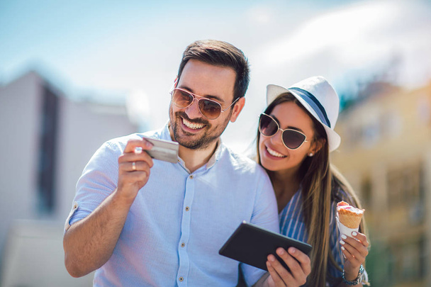 Ευτυχισμένο ζευγάρι που πληρώνει σύμφωνα με την πιστωτική κάρτα και το ψηφιακό δισκίο  - Φωτογραφία, εικόνα