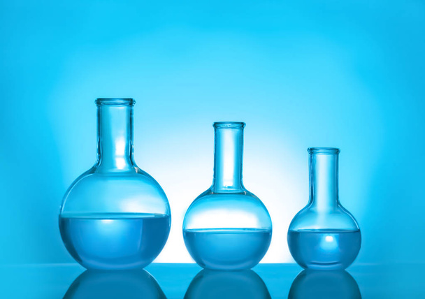 Laboratory glassware with liquid on color background. Solution chemistry - Foto, Imagem