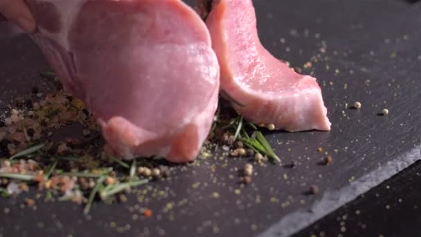 Tumbling raw pork chops with the bone in the mix of spices - 映像、動画