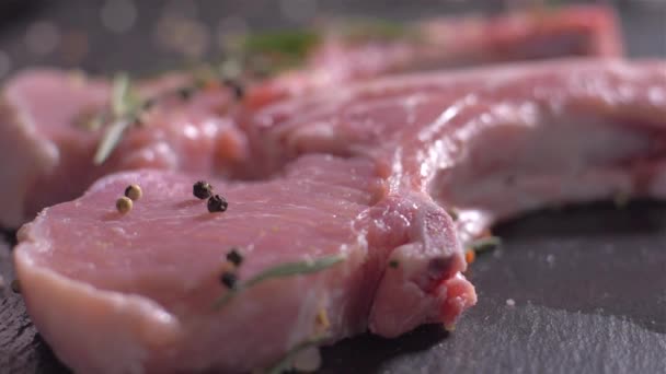 Sprinkling of raw pork chops with bone with a mix of spices - Filmagem, Vídeo