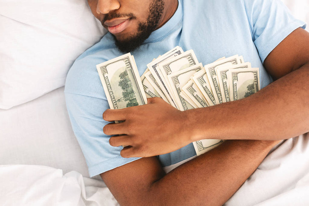 Чоловік спить з великою кількістю валютних банкнот
 - Фото, зображення