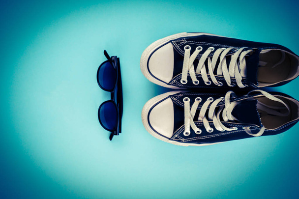 Sneakers e occhiali su sfondo blu
 - Foto, immagini