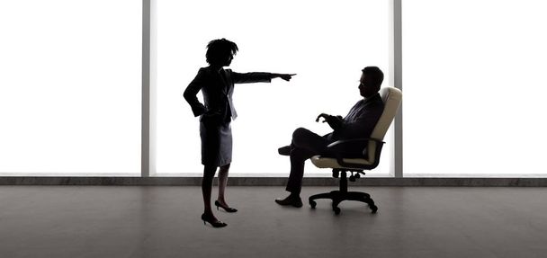 Silhouettes of a businessman and businesswoman fighting.  The business partners are having startup problems or a worker getting fired by a boss because of discrimination. - Photo, Image