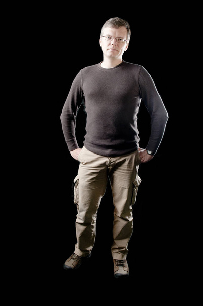 Low key lighting of a handsome man in modern casual clothing - Фото, зображення