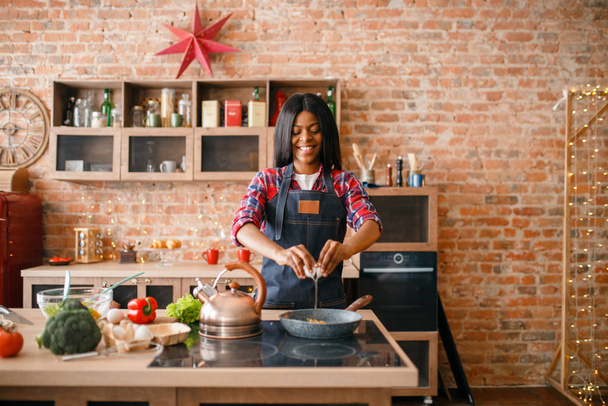 schwarze weibliche Person beim Kochen von Spiegeleiern in der Küche. Afrikanerin bereitet Frühstück zu Hause zu. gesunde vegetarische Lebensweise, vegane Ernährung - Foto, Bild
