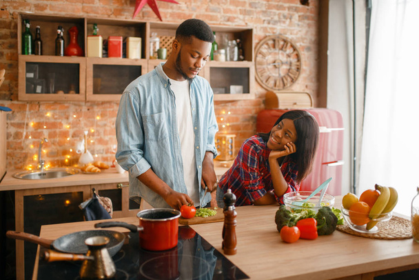Siyah aşk çift mutfakta romantik akşam yemeği pişirme. Afrikalı aile evde sebze salatası hazırlıyor. Sağlıklı vejetaryen yaşam tarzı - Fotoğraf, Görsel