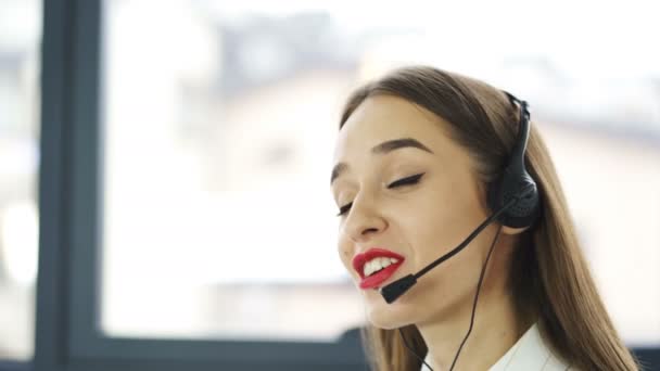 4K. Centro de llamadas. Mujer bonita operador en auriculares respuesta cliente en la oficina
 - Metraje, vídeo