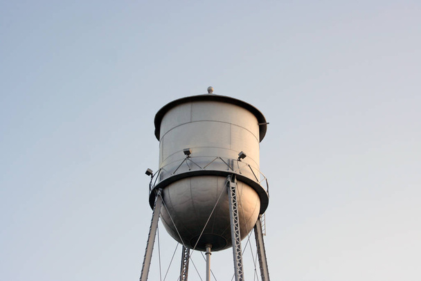 Una vieja torre de agua de plata perdida en el cielo azul
 - Foto, imagen