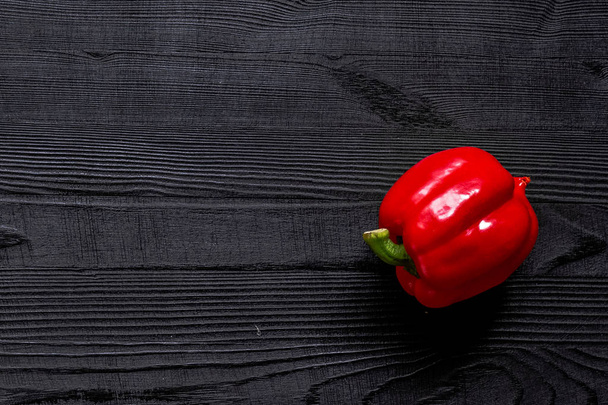 Red sweet bell pepper on black rustic wooden table background. - Foto, afbeelding
