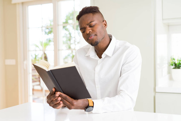 大学の勉強本を読んで若いアフリカ男 - 写真・画像