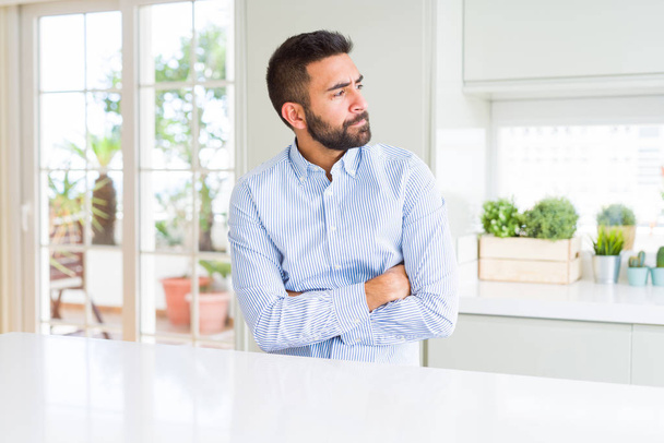 Handsome hispanic business man smiling looking to the side with arms crossed convinced and confident - Photo, Image