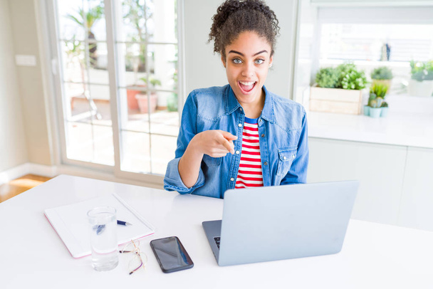 Νέος Αφρικανός Αμερικανός φοιτητής γυναίκα χρησιμοποιώντας φορητό υπολογιστή πολύ χαρούμενοι δείχνοντας με το χέρι και το δάχτυλο - Φωτογραφία, εικόνα