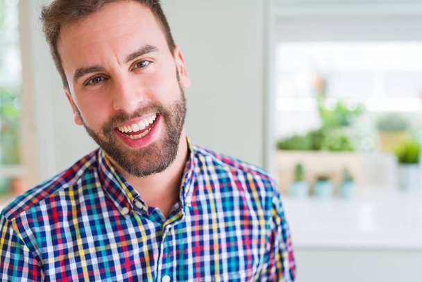 Hombre guapo vistiendo camisa colorida y sonriendo positivo en el
  - Foto, imagen